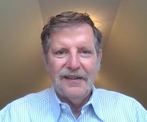 Man with a mustache wearing a blue and white striped shirt