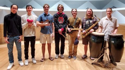 People standing in a semi-circle holding musical instruments