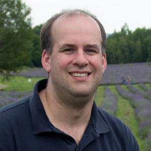 Image of a man in a blue shirt smiling