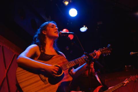 Photo of Gemma Laurence singing and play guitar