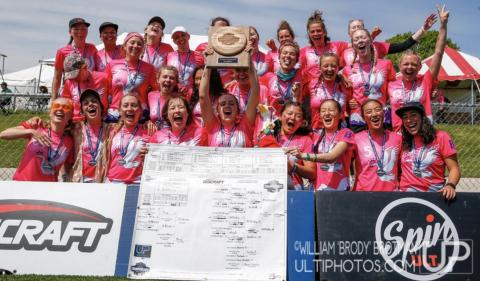 Picture of the Frisbee team winning a tournament, with a banner and a tropy in front of the team