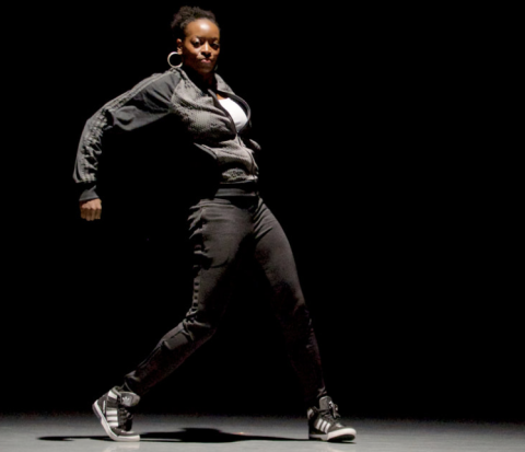 artist dancing against a black background