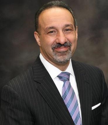 Image of a man wearing a dark suit and tie