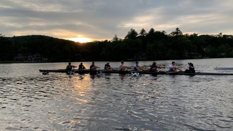 An 8-shell cuts across serene Lake Dunmore with the setting sun visible in the background.