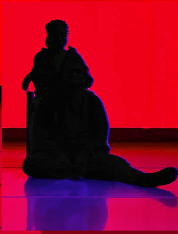 silhouette of a person sitting in a chair against a red background