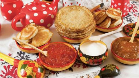 Food typically enjoyed on Maslenitsa on a colorful table.