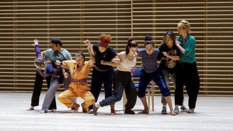 Dancers with arms linked, in a line.