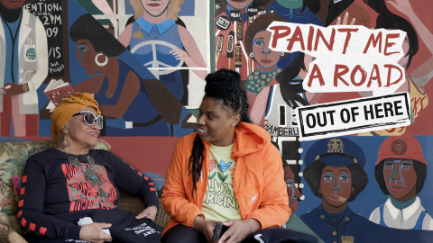 To women artists sitting next to each other, in front of folk style mural. Title of film featured in the upper right as part of the painting.