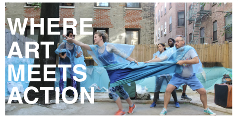 Photo of three people holding on to fabric connected to a fourth person who is trying to move toward the words "WHERE ART MEETS ACTION".