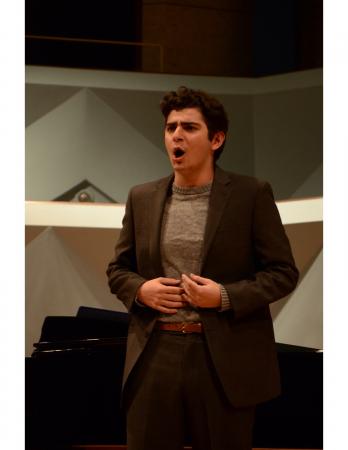 Student performers and accompanist on stage standing around a piano