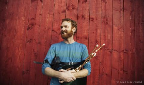 Man holding bagpipes smiling