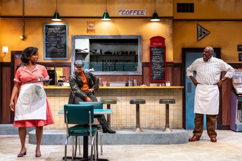 a scene from the play; three people in a restaurant