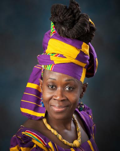 One woman smiling wearing colorful traditional clothing.
