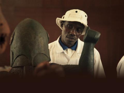 Person in a white hat and white shirt looking at someone in metal armor