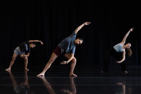 3 dancers dancing against a black background