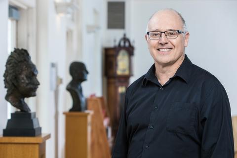 Man with glasses, smiling.