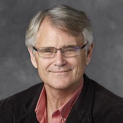 Man in glasses smiling.