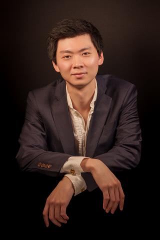 portrait of a young man in suit jacket with arms crossed