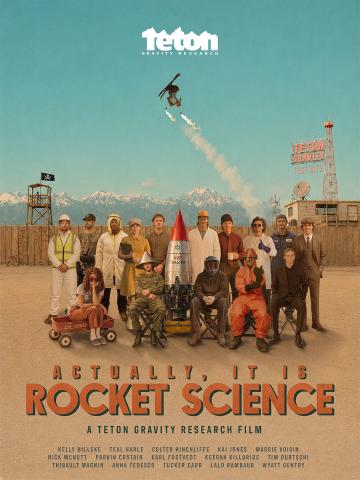 Professional skiers and riders from Teton Gravity Research (TGR) pose in various costumes in a group shot with a skier doing a backflip above them while holding flaming torches. The title of the ski film is Actually, It Is Rocket Science.