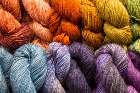 Many colorful skeins of yarn lined up.