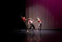 three people dancing in a spotlight