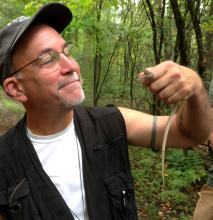 Image of a man wearing a hat in the woods.