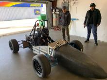 Hybrid race car, with the Middlebury logo and college students