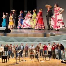 people dancing in bright costumes and musicians standing on a stage with their instruments