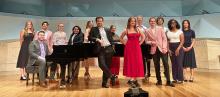 Photo of students in the Concert Hall around the piano.