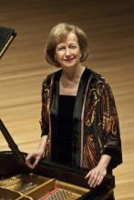 artist standing at a piano
