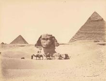 Desert image with pyramids in the background and camels and riders in the foreground