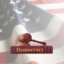 Book with "Democracy" and flag in the background.