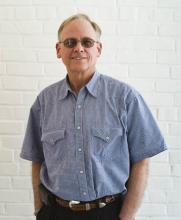 George Thompson standing in front of a brick wall