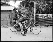 black and white photograph of three people on bicycles