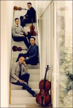 members of the quartet sitting on stairs with their instruments