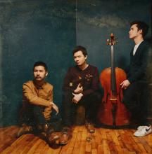 the artists in front of a dark background