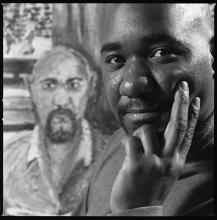 Michelangelo Lovelace in 2001, in front of a self-portrait. Photograph by Herb Ascherman Jr.