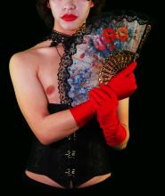 Close up of a person wearing red gloves and holding a fan