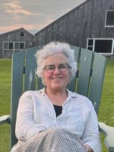 Image is a picture of the guest speaker sitting in a chair on the grass.