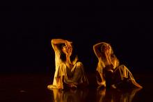 Two dancers against a dark background