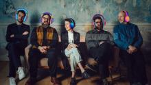 five seated people wearing headphones