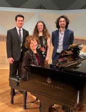 Students and their accompanist on stage standing near the piano