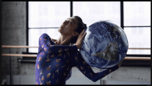 the artist dancing, holding a globe