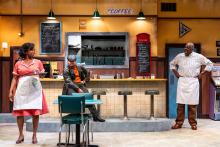 a scene from the play; three people in a restaurant