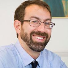 Man smiling with glasses.