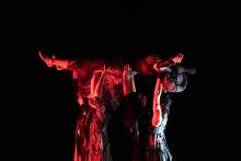 people dancing under a red light with a black background