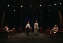 four actors on stage, two standing and two seated