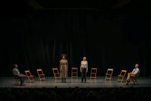 four actors on stage, two standing and two seated