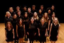 Singers dressed in black, standing on stage