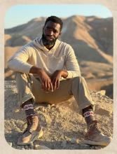 Alzo Slade sitting on sand